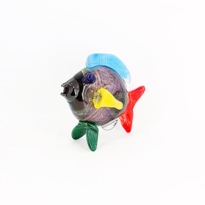 figurine de poisson en verre aux couleurs vives posée sur un fond blanc