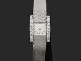 a close up of a watch on a black surface with a black background