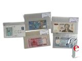 several different types of currency are displayed on a white surface