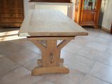 a wooden table in the middle of a tiled floor