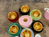 a lot of cups and saucers sitting on a table