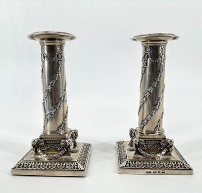 paire de bougeoirs plaqués argent avec des chaînes sur les socles