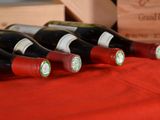 bottles of wine are lined up on a red table cloth