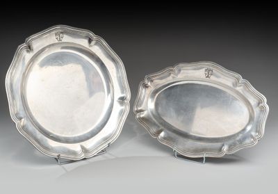 une paire de plats argentés posés sur des supports, sur une table