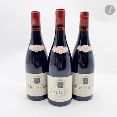 trois bouteilles de vin rouge posées l'une à côté de l'autre sur une surface blanche