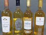 quatre bouteilles de vin posées les unes à côté des autres sur une table