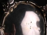 a close up of a silver plate with a face on it