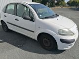 a picture of a small white car parked in a parking lot