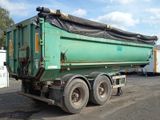 a green dump truck that is parked in a lot