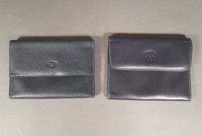 two black leather wallets sitting next to each other on a table