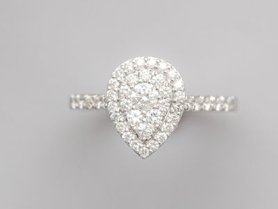 a white gold and diamond ring with a pear shaped center stone