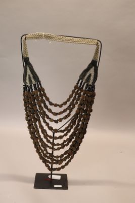 a close up of a necklace on a stand on a white background