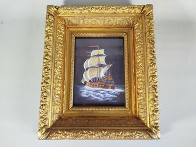 une photo d'un tableau représentant un bateau, dans un cadre doré