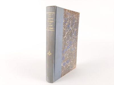 an old book sitting on top of a white table next to a white wall