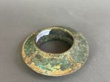 an image of a green and gold ring on a table