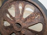 a rusted wheel that is sitting on the floor