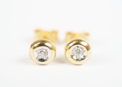 a pair of diamond stud earrings on a white background