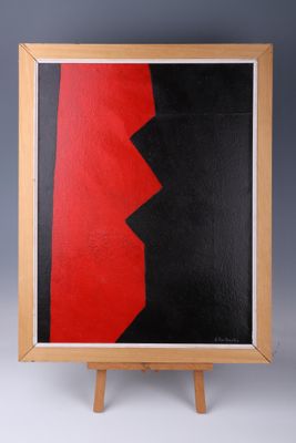 une peinture abstraite rouge et noire posée sur un chevalet en bois