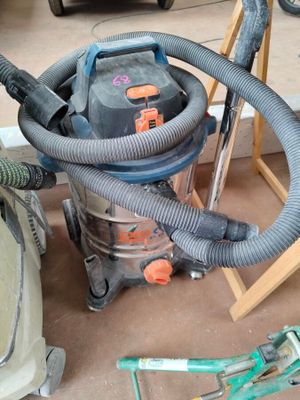 a vacuum that is sitting on the floor next to a chair