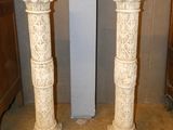 two white marble pedestals in the corner of a room