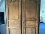 a large wooden armoire in the corner of a room
