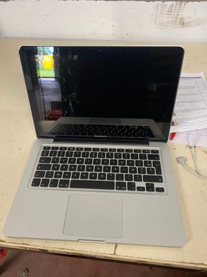 un ordinateur portable ouvert posé sur une table en bois