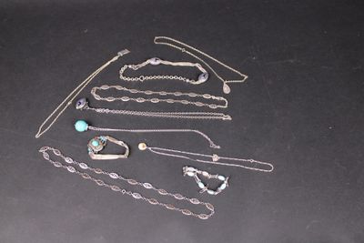 de nombreux bijoux en argent posés sur une table noire