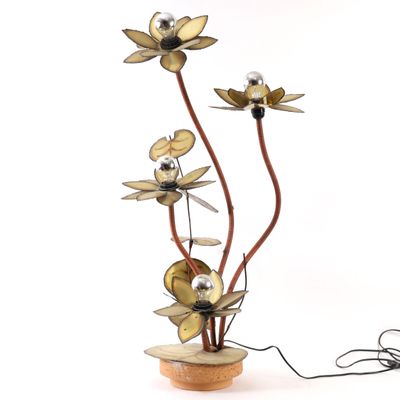 a vase with flowers made of metal on a table