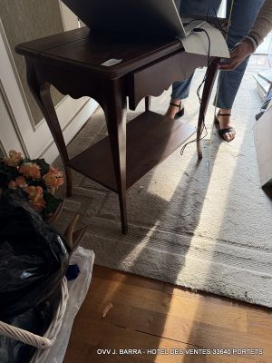woman using a laptop computer on a small table in a living room