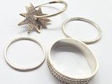 three silver rings with a star on top of them on a white surface