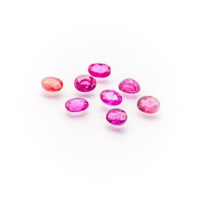 a group of pink and red gems on a white surface