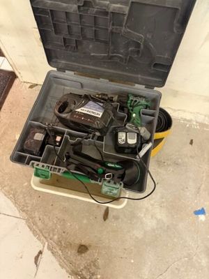une boîte à outils contenant des outils, posée sur le sol