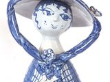 a blue and white figurine of a woman with a dog