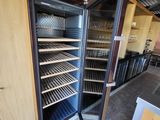 un réfrigérateur ouvert contenant de nombreuses étagères remplies de bouteilles de vin