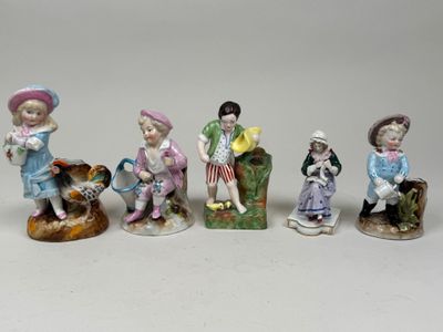 several figurines of children sitting on a bench with a dog
