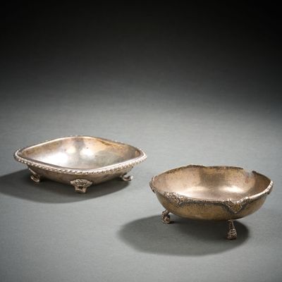 paire de plats en argent posés sur un socle, sur un fond gris