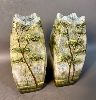 deux vases décorés d'arbres, posés sur une table