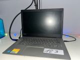 un ordinateur portable posé sur un bureau, avec une étiquette de prix dessus
