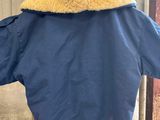 blue jacket on a mannequin head in front of a building