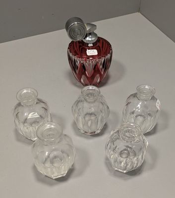 des bouteilles et des verres posés sur une table, avec un vase rouge en arrière-plan