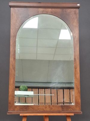 un miroir posé sur un pied, dans lequel se reflète une plante