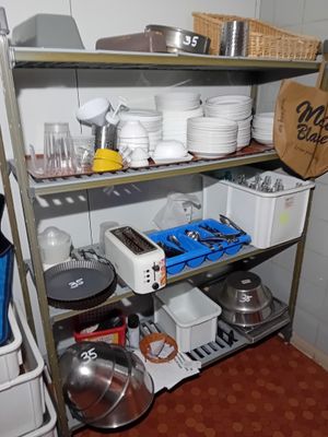 une étagère avec des casseroles et des poêles dans une cuisine