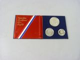 a red, white and blue book with three coins in it