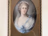 un tableau représentant une femme en robe bleue accroché au mur
