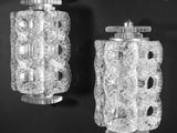 pair of clear glass wall sconces mounted on a black wall