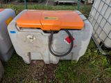 une glacière orange et blanche posée dans l'herbe