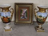 two vases sitting next to a picture on a table
