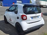 a small white car that is parked in a parking lot