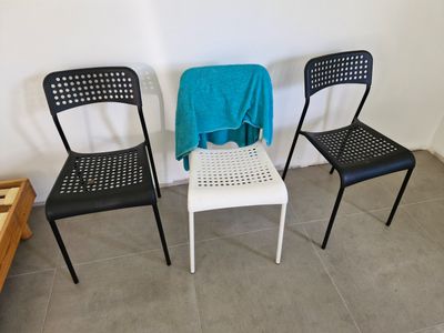 Trois chaises en métal noir et blanc