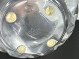 a glass vase with a clock on it sitting on a table